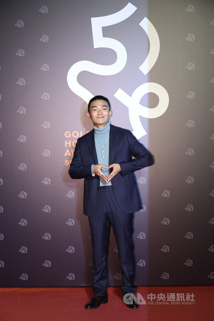 演員胡智強憑藉電影「一家子兒咕咕叫」雙料入圍最佳新演員及男配角,在紅毯上比出愛心手勢。中央社記者張新偉攝 111年11月19日