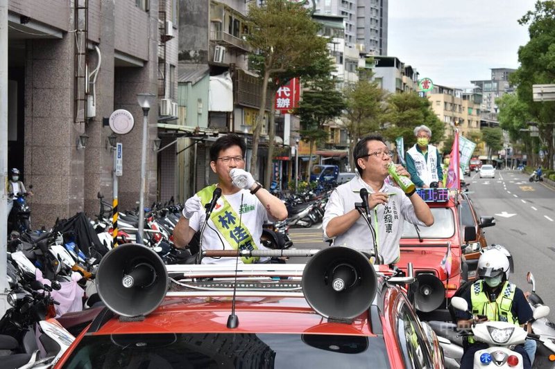 選戰進入最後倒數，民進黨新北市長候選人林佳龍（前左）22日與民進黨立委沈發惠（前右）在新店區車隊掃街拜票，已經燒聲的林佳龍喝水補充水分。中央社記者高華謙攝  111年11月22日