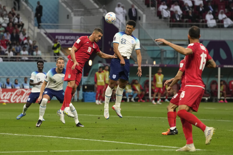 英格蘭21日在卡達世界盃足球賽首戰以6比2擊退伊朗，19歲小將貝林翰（前左4）頭錘破門幫助英格蘭取得1比0領先。（美聯社）