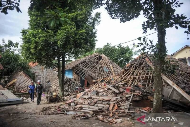 印尼西爪哇省的席安約鎮21日發生規模5.6淺層強震，已造成268人死亡。圖為民眾行經遭震倒的房屋。（安塔拉通訊社）