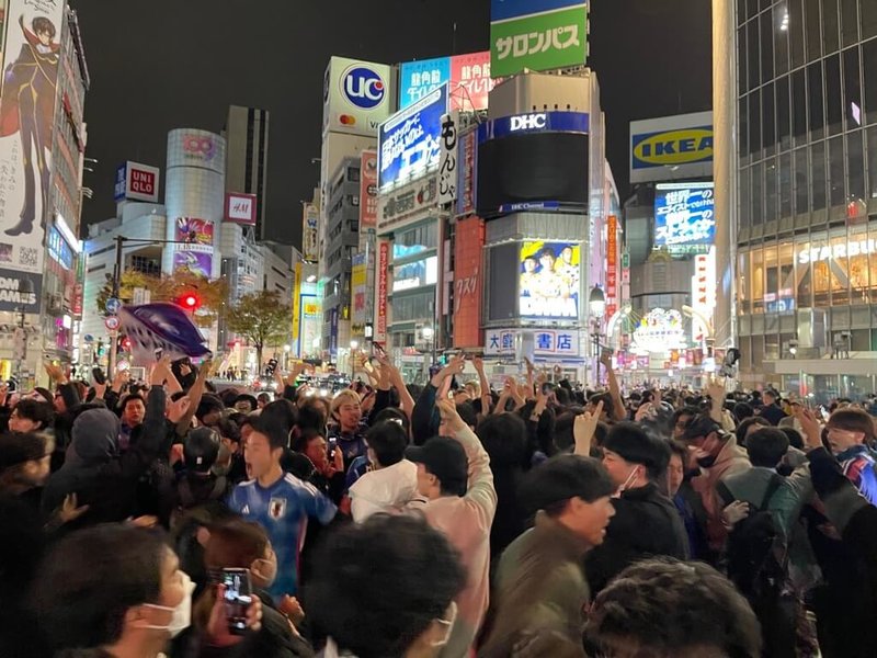 日本隊23日在卡達世界盃中爆冷擊退德國隊，日本球迷在東京澀谷車站前狂歡，綠燈時球迷衝進十字路口狂賀，紅燈時退到一旁人行道上。（讀者提供）中央社 111年11月24日