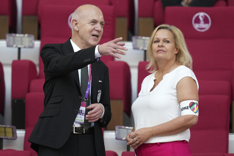 戴著彩虹臂章的德國內政部長費瑟（右）23日坐在FIFA主席英凡提諾（左）旁看球。（美聯社）