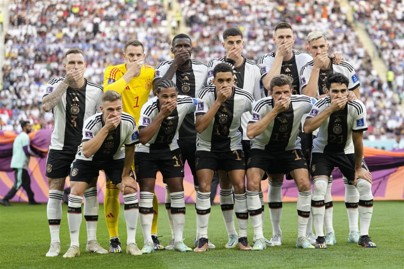 德國隊球員23日用手摀住嘴巴對FIFA禁止球隊配戴彩虹臂章表示抗議。（美聯社）