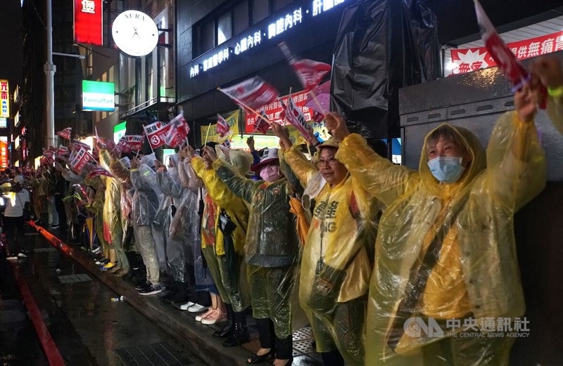 民進黨基隆市長候選人蔡適應25日選前之夜舉辦「點亮基隆 手護光榮」遊行活動,儘管天氣不佳,仍有許多支持者穿著雨衣熱情揮舞旗幟,高喊「凍蒜」、基隆加油等口號。中央社記者王揚宇攝 111年11月25日