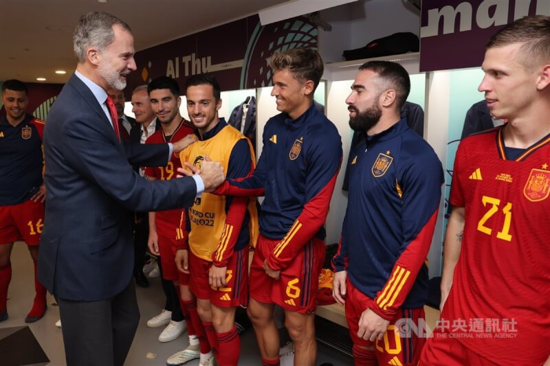 西班牙國王菲利佩六世（左）在國家隊贏得世足賽首勝後，在球員更衣室開心地和全體球員握手道賀。（取自西班牙王室Twitter）中央社記者胡家綺馬德里傳真 111年11月25日