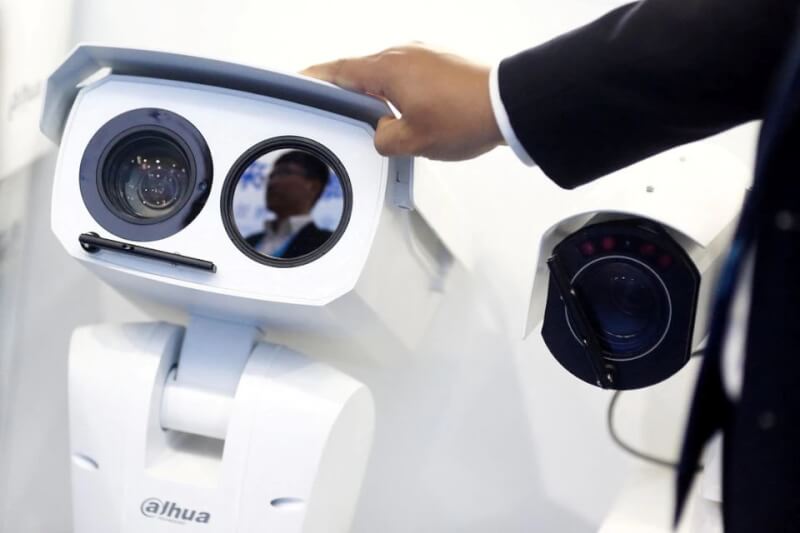 圖為2018年在中國舉行的展覽會上，一名男子調整大華製造的監視攝影機。（路透社）