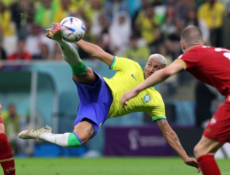巴西24日世足賽對戰塞爾維亞，球員理查利森（左）在比賽第73分鐘展現倒掛金鉤美技，率隊奪勝。（路透社）