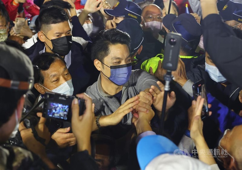 台北市長選舉結果大勢已定，國民黨候選人蔣萬安（中）26日晚間自行宣布當選，進場時受到支持群眾簇擁，他也親切向支持者致意。中央社記者張新偉攝 111年11月26日