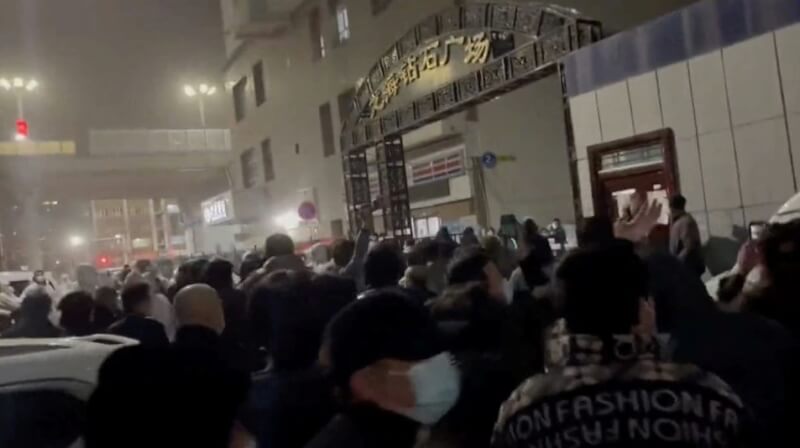 25日發布的影片顯示，烏魯木齊民眾齊聚抗議官方防疫措施。（翻攝畫面／路透社）