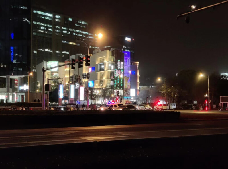 白紙運動參與民眾28日晚計劃轉往四通橋表達訴求，但警方早已在週邊布署龐大警力戒備。圖中遠處為四通橋附近的領展商場，前方可見至少停放2輛警用廂型車。（取自推特）中央社記者邱國強北京傳真 111年11月28日