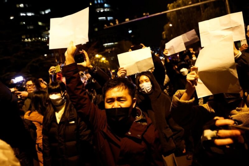 北京民眾27日手持白紙，上街抗議官方過度防疫。（路透社）