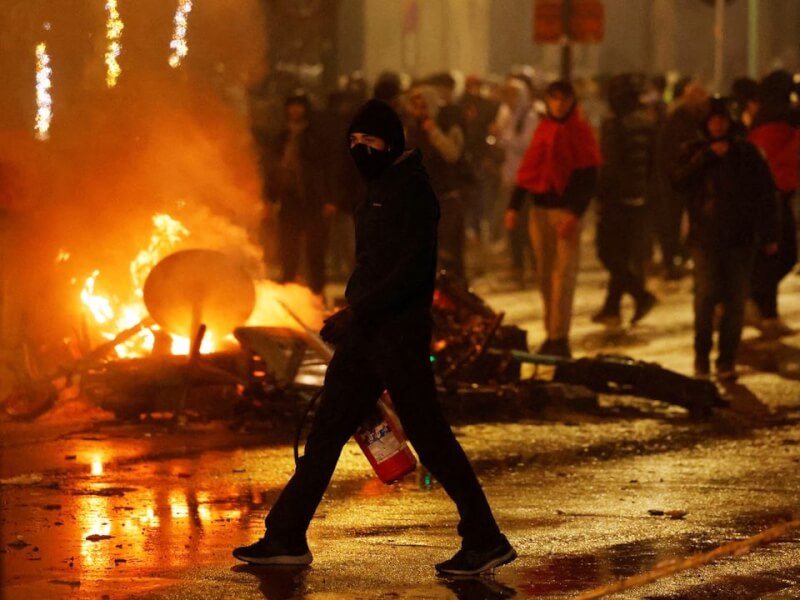 比利時27日在世足賽爆冷踢輸摩洛哥後，布魯塞爾市區出現街頭暴力，有人蒙面對電動滑板車縱火。（路透社）