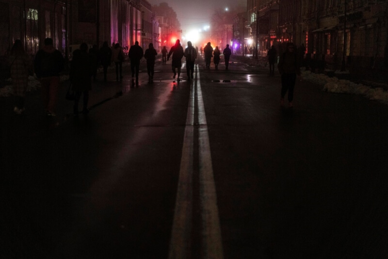 圖為24日基輔民眾走在漆黑街頭。（美聯社）