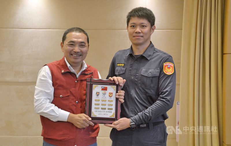 新北警方破獲「台版柬埔寨」求職詐欺拘禁案件,市長侯友宜(左)30日在市政會議中,表揚偵破有功的淡水警分局警員蘇子軒(右)等有功人士,頒贈階級章獎牌。中央社記者黃旭昇新北市攝 111年11月30日