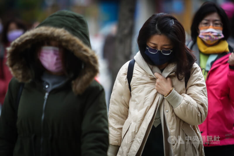氣象專家吳德榮說，北台灣11月30日晚間、12月1日清晨最冷。圖為台北街頭民眾拉緊外套阻擋寒風。（中央社檔案照片）
