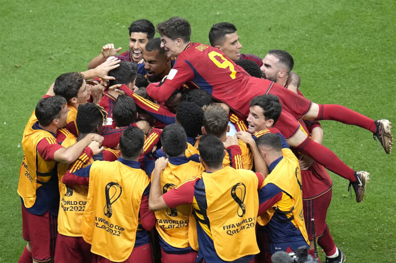 西班牙27日在世足小組賽對決德國，前鋒莫拉塔進球後，開心與隊友慶祝。（美聯社）