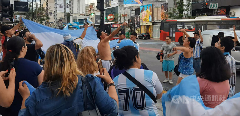 阿根廷球迷于卡达世界杯第三场小组赛完胜波兰后，开心地聚集于街头，一起庆祝，除了摇旗呐喊，更一起唱著属于世界杯的阿根廷球迷加油歌曲，一旁街道行驶过的车辆也按喇叭共同庆祝进16强的一刻。中央社记者黄韵如布宜诺斯艾利斯摄 111年12月2日