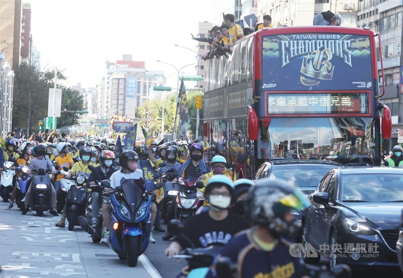 球員們所搭乘雙層巴士旁，有球迷組成機車車隊一路相隨，前進終點南港中國信託金融園區。中央社記者張新偉攝 111年12月3日