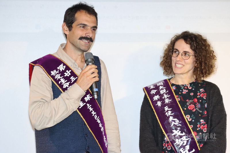 土耳其色盲藝術家法提．庫屈克（左）3日在台北獲頒周大觀文教基金會「全球熱愛生命獎章」，與妻子格尼爾（右）上台致詞。中央社記者何宏儒攝  111年12月3日