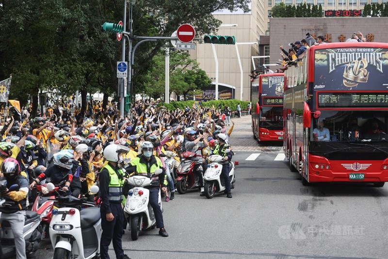 中華職棒中信兄弟隊台北封王遊行感謝祭3日中午從北市府前廣場前正式出發，行經逸仙路口時，許多球迷在路旁守候，興奮向球隊選手們揮手。中央社記者張新偉攝 111年12月3日