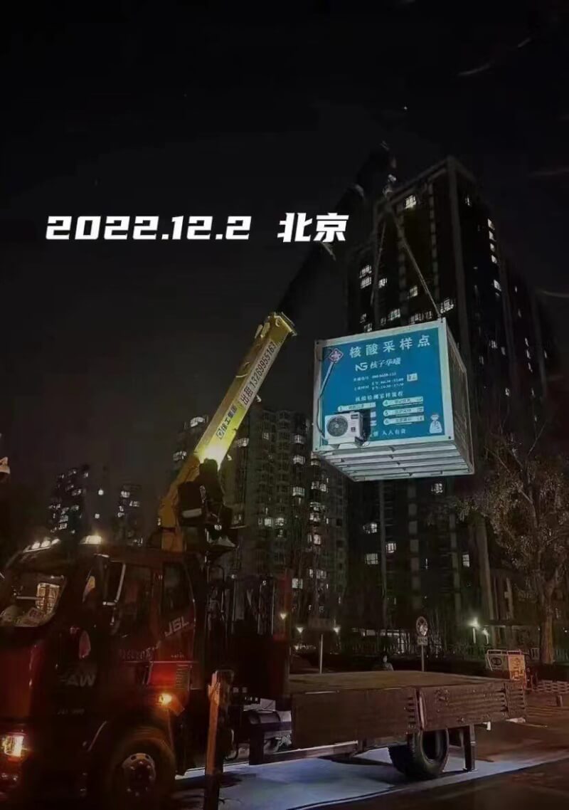 中國防疫加速鬆綁加速。中國網路2日出現一張照片，畫面是北京市一座核酸檢測亭被機具吊離、並註明2022年12月2日，立刻成為熱門梗圖，被認為是中國的核酸時代宣告結束。（取自網路）中央社記者邱國強北京傳真 111年12月3日