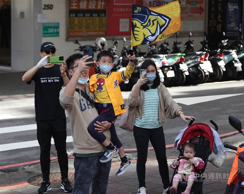 遊行3日中午從台北市政府前廣場前出發，前進終點南港中國信託金融園區，沿途有球迷帶著家中小朋友在路口等待。中央社記者張新偉攝　111年12月3日