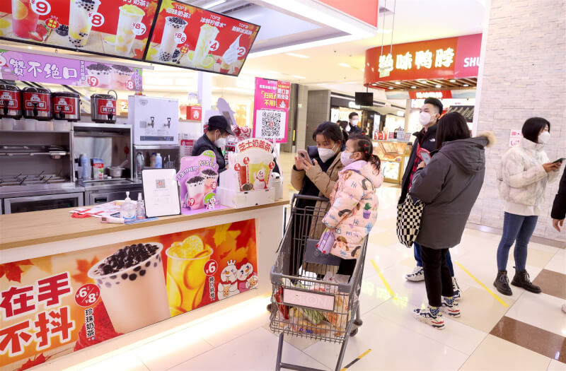 中國許多城市防疫鬆綁，原本關閉的大型商場陸續恢復營業，民眾3日在北京購物中心逛街購物。（中新社）