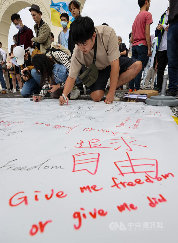 多個台灣民團4日齊聚台北自由廣場聲援中國白紙運動，不少民眾在大型白布條上寫下對中國民眾的鼓勵，表達支持立場。中央社記者鄭清元攝  111年12月4日