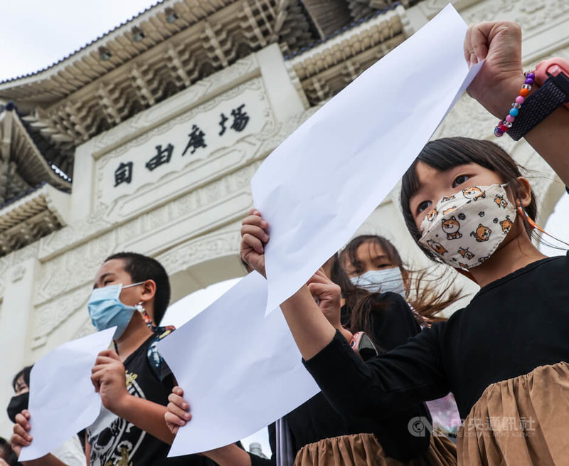 中國白紙運動持續延燒，多個台灣民團4日在台北自由廣場前聲援白紙運動，有孩童舉起白紙加入隊伍，與大人一同表達支持。中央社記者鄭清元攝  111年12月4日