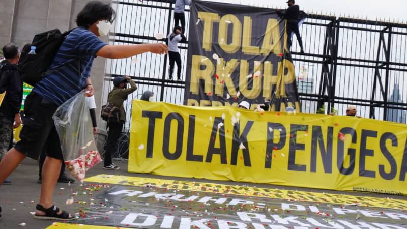 印尼民眾反對通過刑法修正草案，5日在抗議布條撒下鮮花，象徵印尼民主已死。美國外交官員指出，這項法規可能嚇跑外國遊客及降低外資來印尼意願。中央社記者李宗憲雅加達攝 111年12月5日