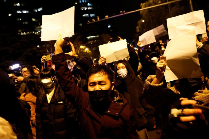圖為去年11月27日北京民眾手持白紙抗議防疫清零政策。（路透社）