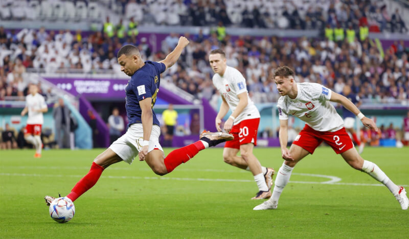 法國5日在卡達世界盃足球賽16強賽對戰波蘭，姆巴佩（前左）下半場兩度破門，最終法國以3比1勝出，晉級8強。（共同社）