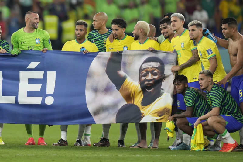 巴西5日在世界盃擊敗韓國晉級世足8強，球賽結束後，球員們拿著有球王比利名字和照片的橫幅進入球場致敬。（美聯社）