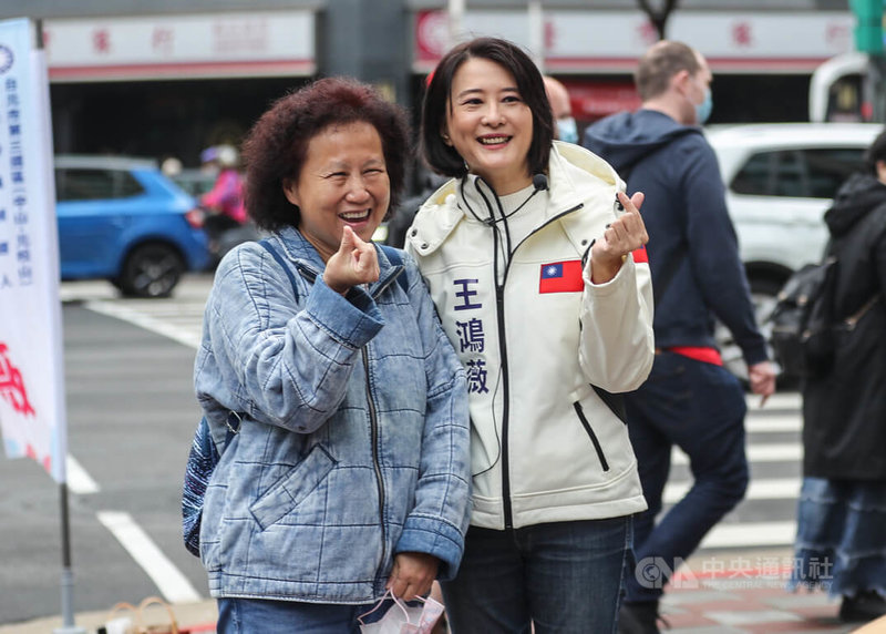 國民黨台北市第3選區立委補選參選人王鴻薇（右）8日上午至松江南京路口拜票，民眾上前合影，為她加油打氣。中央社記者裴禛攝  111年12月8日