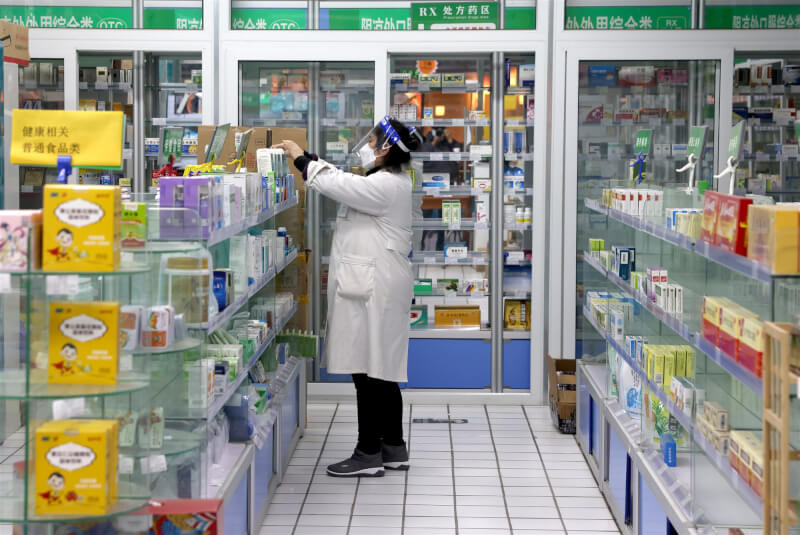 中國7日公布防疫「新10條」，大幅放寬檢疫規定，在冬季染疫人數恐大增的擔憂下，各地掀囤藥、囤口罩潮。圖為7日北京一家藥局工作人員正在整理藥品。（中新社）