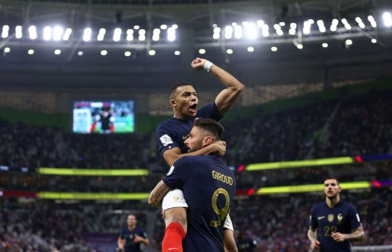 法國5日於卡達世足16強賽擊敗波蘭，球員姆巴佩（前左）跳進前鋒吉魯（前右）懷中開心慶祝。（路透社）