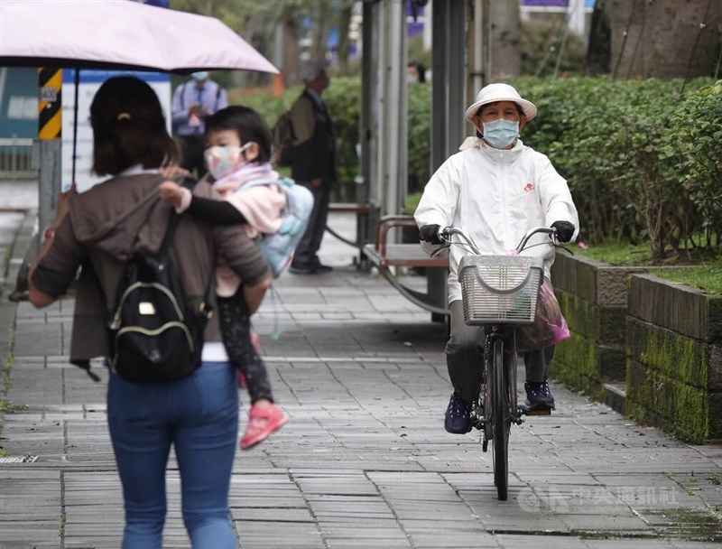 中央氣象局10日發布雙北及基隆、宜蘭地區大雨特報。圖為南港展覽館民眾穿著雨衣騎單車。（中央社檔案照片）