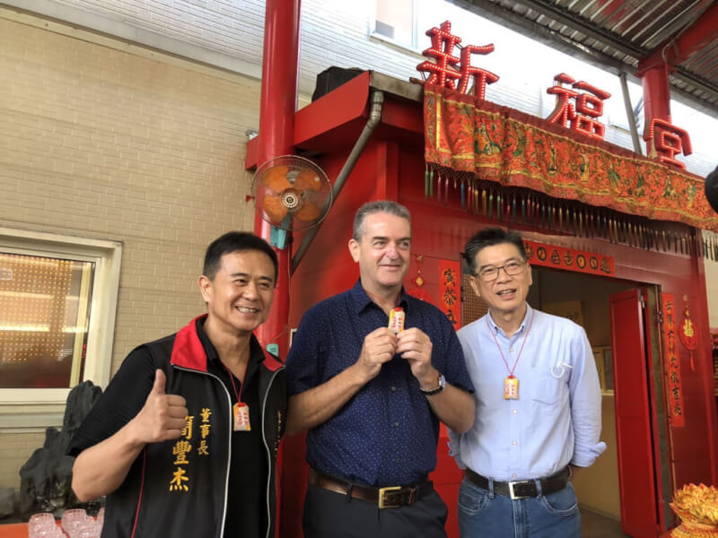 法國飛機製造商亞太區總經理波托茲基(Christophe Potocki)(中)10日前往台中市東區新福宮還願,展示配戴的平安符。中央社記者趙麗妍攝 111年12月10日