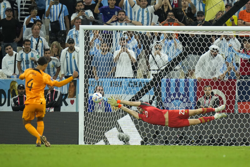 世界盃足球賽阿根廷對荷蘭進入PK大戰，阿根廷靠著門將馬蒂內茲（前右）救下2球，以4比3險勝，搶下4強門票。（美聯社）
