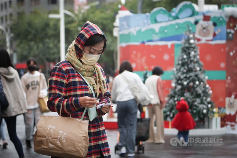 圖為新北市板橋區外出民眾穿厚外套、戴圍巾加強保暖。中央社記者王騰毅攝 111年12月12日