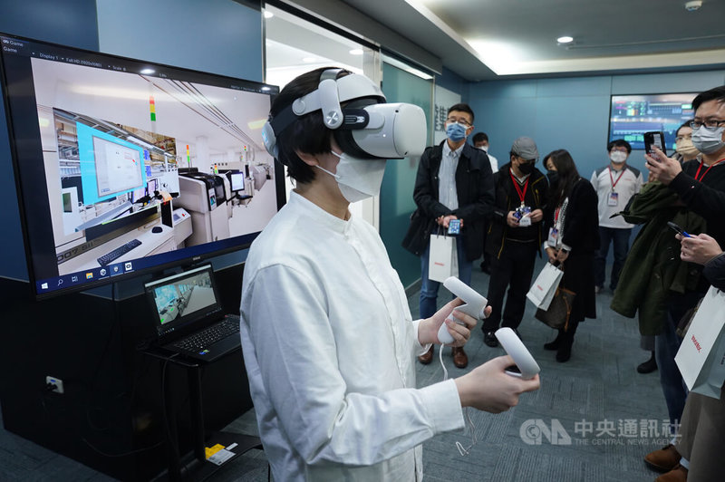 英業達14日與英特爾、微軟共同舉辦5G Next Lab開幕儀式，工作人員戴上VR裝置示範在智慧工廠上的應用。中央社記者徐肇昌攝 111年12月14日