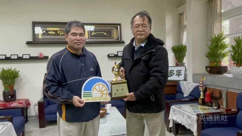 金門縣多年國小校園建置風力發電機、太陽能板和腳踏車發電機組，致力推展能源教育，獲經濟部推動能源教育標竿獎銀獎，校長張志猛（右）14日展示獎牌。中央社記者黃慧敏攝  111年12月14日