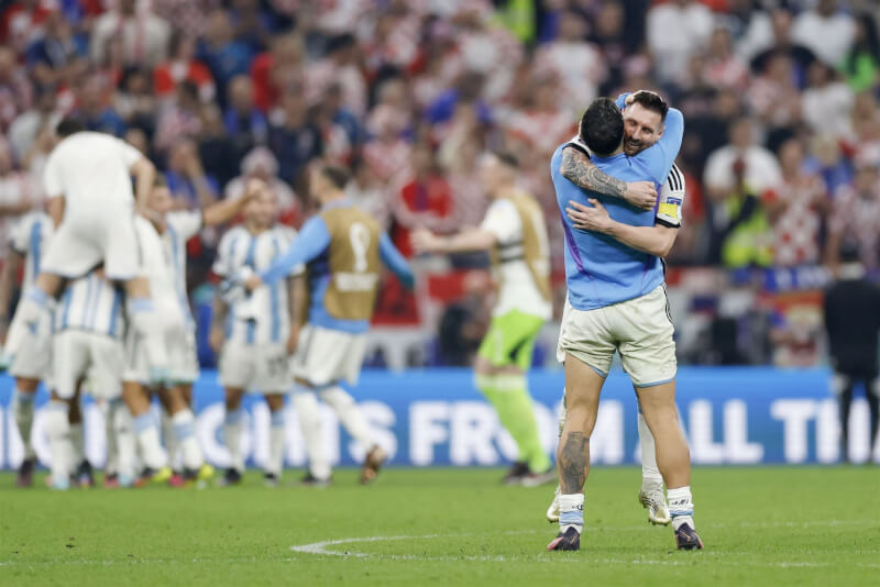 阿根廷14日在世界盃擊敗克羅埃西亞，球評分析阿根廷全隊想幫助梅西拿下冠軍的氛圍強烈。圖為阿根廷挺進決賽後，梅西（面對鏡頭者）與隊友擁抱。（共同社）