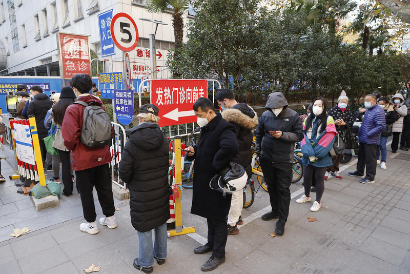 中國疫情飆升迅速蔓延，中國國家衛健委官員15日宣布，為了提升基層應對能力，可以招聘近5年來已經退休的工作人員，充實到基層醫療衛生機構。圖為15日，上海民眾在醫院外排隊。（中新社提供）中央社 111年12月15日