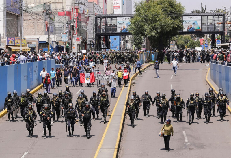 反對前總統卡斯蒂約遭罷黜與逮捕的暴力示威導致7人喪生後，秘魯14日宣布全國進入緊急狀態。圖為14日警方與抗議人群走在秘魯的街道上。（路透社）