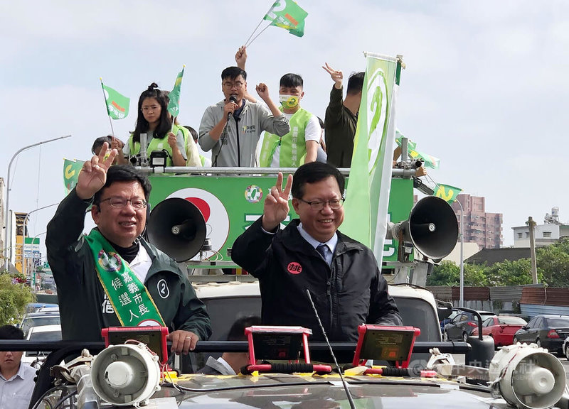 民進黨嘉義市長候選人李俊俋（前左）16日在桃園市長鄭文燦（前右）陪同下車隊掃街拜票，衝刺選情。中央社記者黃國芳攝  111年12月16日