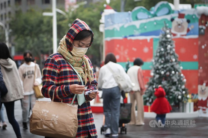 氣象專家吳德榮16日表示，入冬首波寒流晚上起南下，各地氣溫漸降，越晚越冷。圖為新北市板橋區外出民眾穿厚外套、戴圍巾加強保暖。（中央社檔案照片）