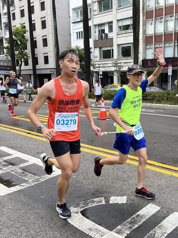 一年一度的台北馬拉松18日將登場，台大醫院16日指出，31歲換心病友陳奕成（前左）也是今年眾多跑者之一，儘管先天右眼全盲，左眼視力也僅0.1，但視障完全阻擋不了陳奕成對運動的熱愛。（台大醫院提供）中央社記者沈佩瑤傳真 111年12月16日