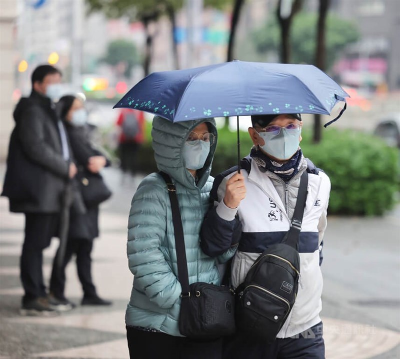 中央氣象局16日針對基隆北海岸發布大雨特報，提醒民眾留意降雨。圖為台北市松山區街頭民眾穿上羽絨衣、厚外套保暖。（中央社檔案照片）