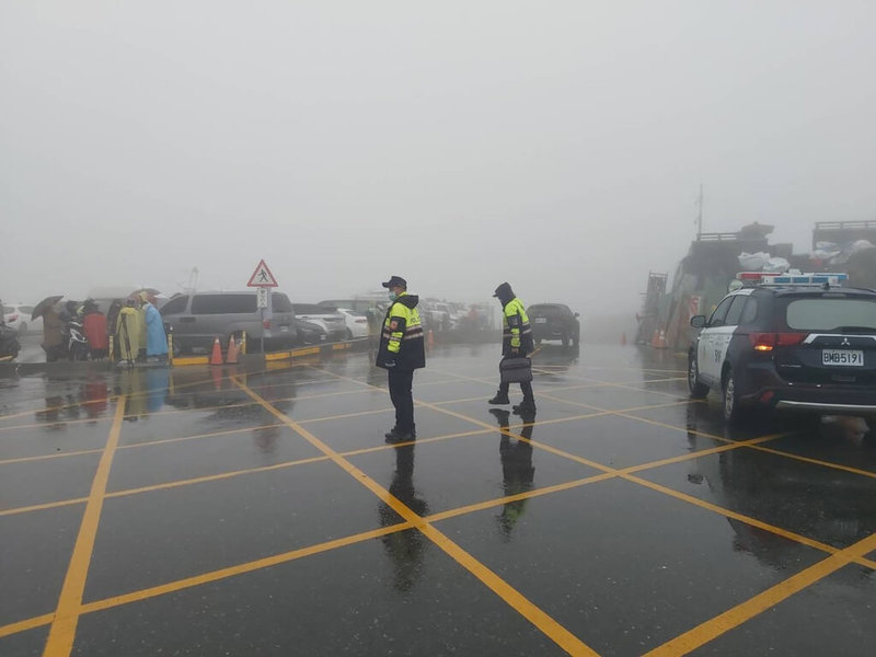 中央氣象局發布低溫特報，不少民眾17日開車前往合歡山想要賞雪，不過合歡山上午飄雨，民眾只好先將車子停在停車場，合歡山上武嶺停車場等因此客滿，員警也到場指揮交通。（南投縣仁愛警分局提供）中央社記者吳哲豪傳真 111年12月17日